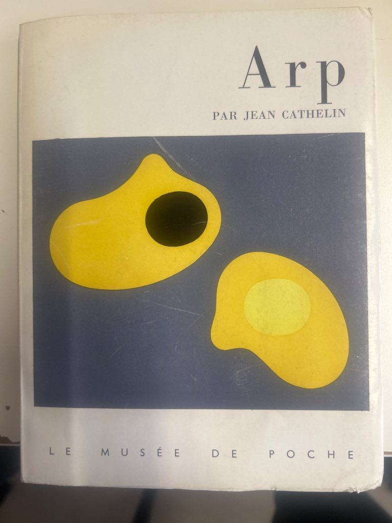 Yellow and blue illustrated wrappers of 1959 Arp monograph from Le Musée de Poche series showing biomorphic sculptures