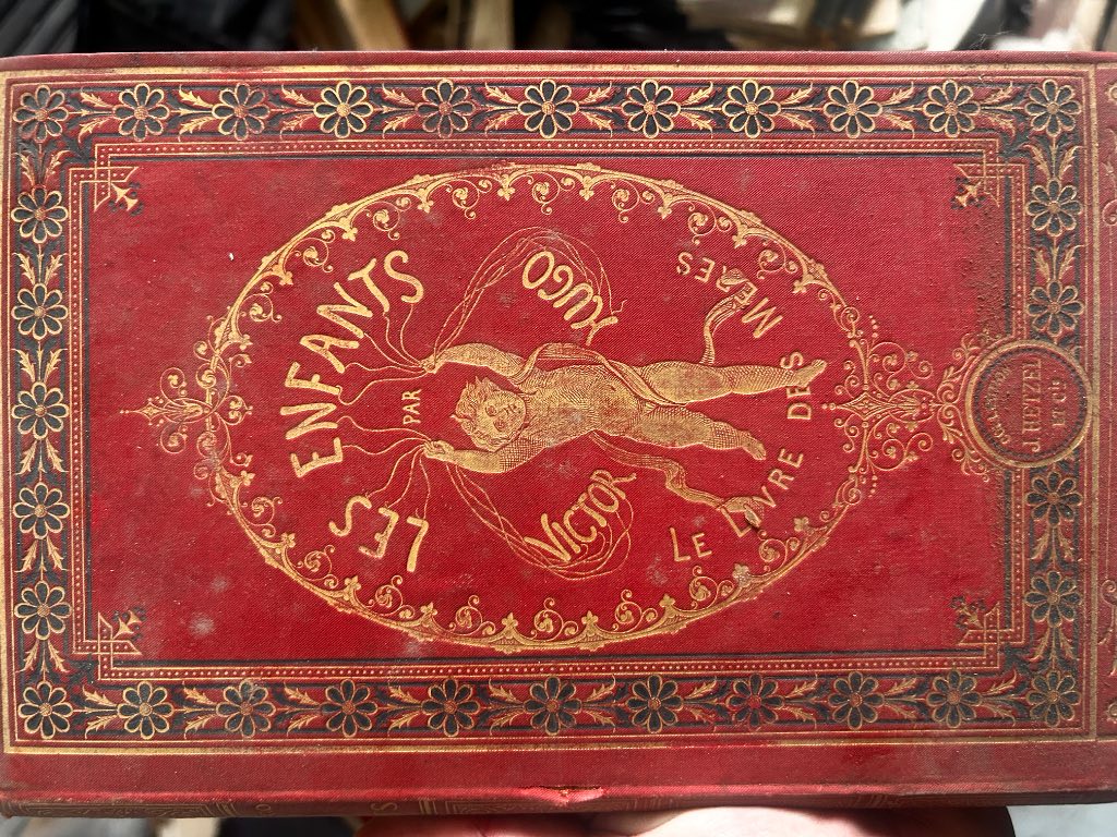 Red percaline binding of Le Livre des Mères by Victor Hugo, Hetzel edition with gilt medallion showing winged putto and flora
